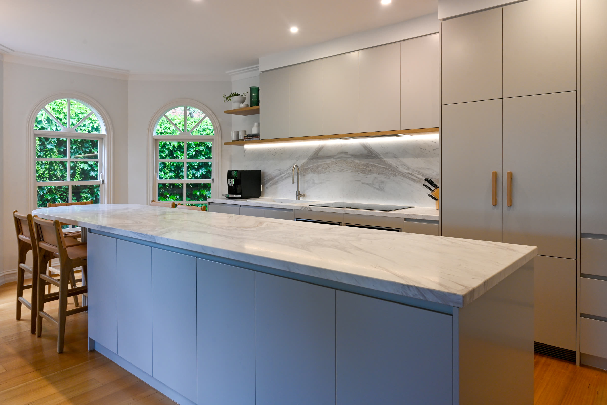 Premium kitchen renovation with blue island, marble waterfall benchtop and arched windows by PMD Projects